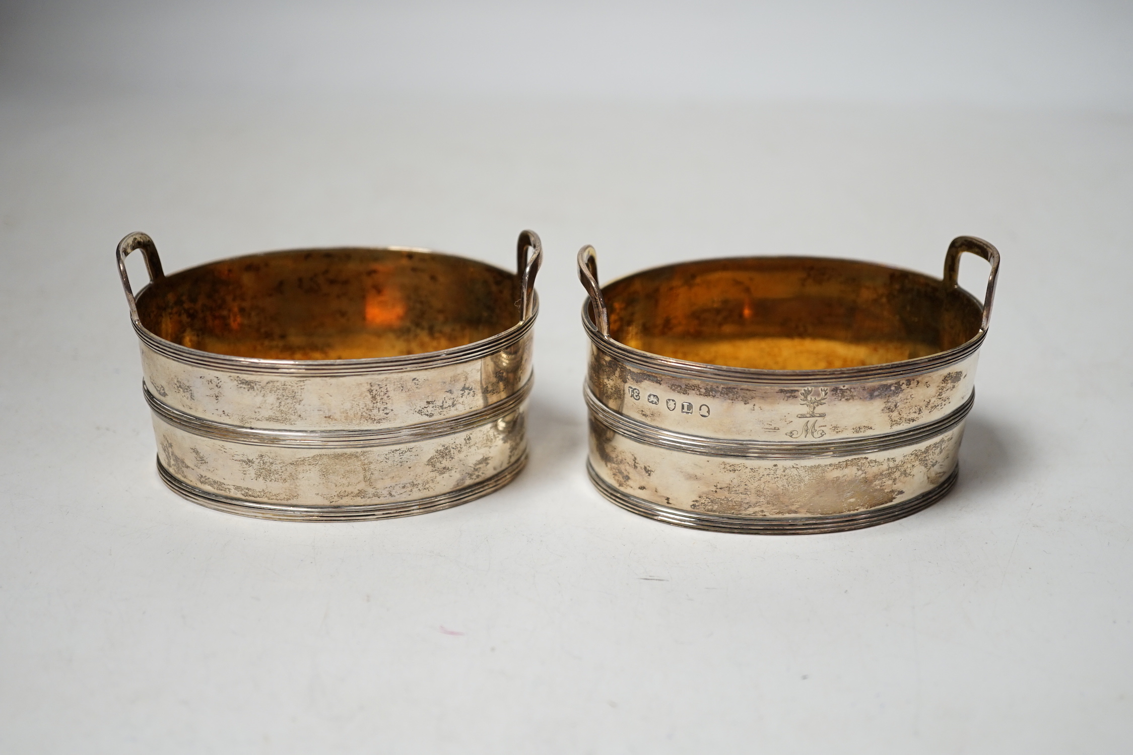 A pair of George III silver salts, modelled and oval two handled tubs, by John Emes, with reeded bands and engraved crest, 89mm.